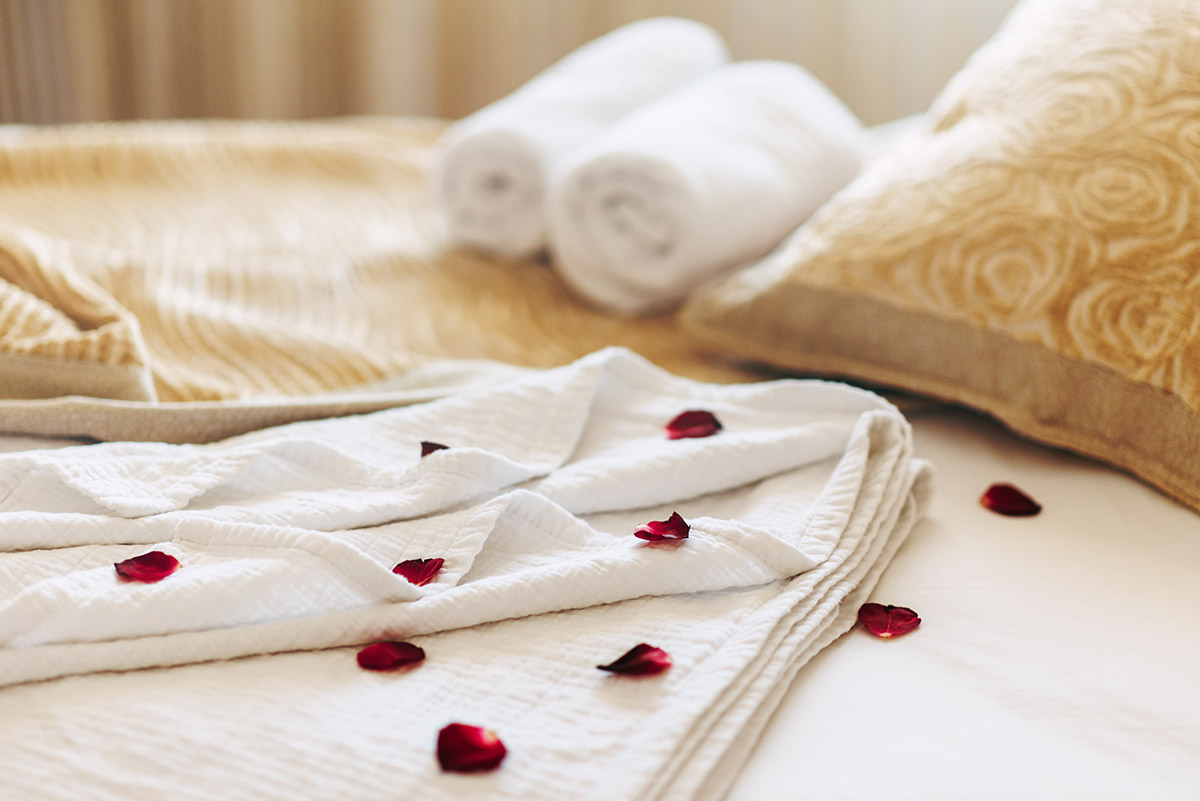 Luxury spa hotel room for romantic weekend. Honeymoon suite bedroom decorated with rose petals.